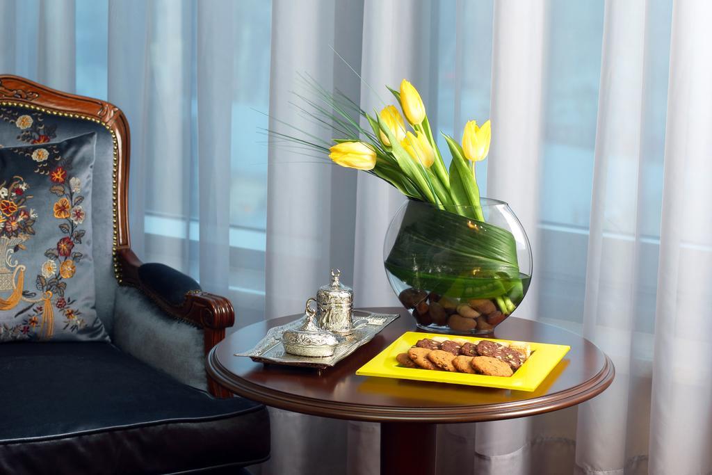 Orion Hotel Bishkek Bagian luar foto A table with a vase of flowers